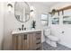 Charming bathroom featuring a vanity with a light wood finish, an oval mirror, and patterned tile floor at 3806 N Tampa St, Tampa, FL 33603