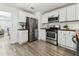 Bright kitchen with stainless steel appliances and white cabinets and subway tile backsplash at 3806 N Tampa St, Tampa, FL 33603
