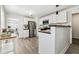 Open kitchen with stainless appliances, wood counters, white cabinets and gray wood flooring at 3806 N Tampa St, Tampa, FL 33603