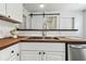 A well-lit kitchen sink with wood countertops, a white subway tile backsplash, and modern faucet at 3806 N Tampa St, Tampa, FL 33603