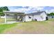 Backyard featuring a shed, covered patio with outdoor seating, grill, and well-maintained lawn at 39423 9Th Ave, Zephyrhills, FL 33542