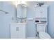 Bathroom showcases a white vanity and wall cabinet against soft blue walls at 39423 9Th Ave, Zephyrhills, FL 33542