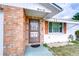 Close up of the front door, brick facade, window with an awning, and house numbers at 39423 9Th Ave, Zephyrhills, FL 33542