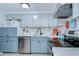 Updated kitchen features stainless steel appliances and light blue cabinets with complementary white countertops and backsplash at 39423 9Th Ave, Zephyrhills, FL 33542