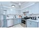 Well-equipped kitchen featuring stainless steel appliances, tiled flooring, and ample storage at 39423 9Th Ave, Zephyrhills, FL 33542