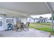 This covered patio provides a shady area with dining table, and a view of the backyard at 39423 9Th Ave, Zephyrhills, FL 33542