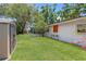 Large manicured lawn features mature trees, landscaping, a storage shed, and a glimpse of the screened-in porch at 4465 1St Ne Way, St Petersburg, FL 33703