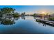 Scenic waterfront view with a wooden dock, calm water, and a beautiful sunset backdrop enhances the property's appeal at 4772 Dover Ne St, St Petersburg, FL 33703