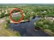 A high, angled aerial view shows the home with nearby lake and surrounding trees at 5058 Westlake Blvd, Dade City, FL 33523