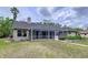 Home featuring an enclosed screened lanai and green lawn at 5058 Westlake Blvd, Dade City, FL 33523