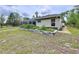Backyard featuring lush green grass, garden plots, and the side of the home at 5058 Westlake Blvd, Dade City, FL 33523