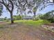 Expansive backyard with a view of the lake beyond the trees, offering a private and serene outdoor space at 5058 Westlake Blvd, Dade City, FL 33523