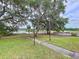 Spacious backyard with mature trees and a serene lake view, perfect for relaxing and enjoying nature at 5058 Westlake Blvd, Dade City, FL 33523
