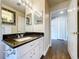Bathroom featuring granite countertop vanity, dual mirrors, and wood-look floors at 5058 Westlake Blvd, Dade City, FL 33523