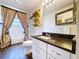 Well-lit bathroom with a vanity with granite countertop and decorative mirror at 5058 Westlake Blvd, Dade City, FL 33523