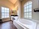 Bathroom featuring a soaking tub, two windows, vanity, and tile flooring at 5058 Westlake Blvd, Dade City, FL 33523