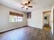 Bedroom with wood-look tile flooring, ceiling fan and a window for natural light at 5058 Westlake Blvd, Dade City, FL 33523