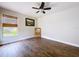 Bright bedroom featuring wood-look floors, a ceiling fan, and a window with woven blinds at 5058 Westlake Blvd, Dade City, FL 33523