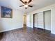 Cozy bedroom with wood-look flooring, ceiling fan, and large closet, offering ample space at 5058 Westlake Blvd, Dade City, FL 33523