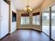 This dining area features a decorative chandelier, wood floors, and slider doors to screened patio at 5058 Westlake Blvd, Dade City, FL 33523