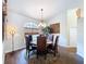 Dining room with hardwood floors, decorative chandelier, and rounded window with wooden blind at 5058 Westlake Blvd, Dade City, FL 33523
