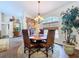 Dining room boasts hardwood floors, chandelier, and rounded window with wooden blind at 5058 Westlake Blvd, Dade City, FL 33523