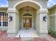 Covered entrance to the home with beautiful brick accents and overhead lighting at 5058 Westlake Blvd, Dade City, FL 33523