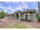 Single-story home with a two-car garage, brick accents, manicured lawn, arched entry and tidy landscaping at 5058 Westlake Blvd, Dade City, FL 33523