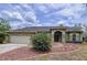Charming home featuring a two-car garage, manicured lawn, arched entry and well-maintained landscaping at 5058 Westlake Blvd, Dade City, FL 33523
