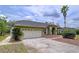 Beautiful single-story home with a well-manicured lawn, a two-car garage and mature landscaping at 5058 Westlake Blvd, Dade City, FL 33523