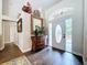 Bright foyer with wood-look tile flooring, decorative mirror, and front door with leaded glass at 5058 Westlake Blvd, Dade City, FL 33523
