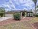 Home's landscaped front exterior with a two car garage and covered entryway at 5058 Westlake Blvd, Dade City, FL 33523