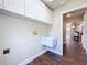 Functional laundry room with sink, cabinets, and stylish wood-look floors at 5058 Westlake Blvd, Dade City, FL 33523