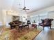 Spacious living room featuring wood-look flooring, ceiling fan, and comfortable seating at 5058 Westlake Blvd, Dade City, FL 33523