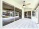 Covered outdoor patio featuring white tile flooring, fan, and sliding glass doors at 5058 Westlake Blvd, Dade City, FL 33523