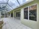 Exterior screened enclosure with white pillars and overhead cover with tile flooring at 5058 Westlake Blvd, Dade City, FL 33523