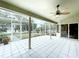 Outdoor patio with tile flooring and screened enclosure; view of trees and lake at 5058 Westlake Blvd, Dade City, FL 33523