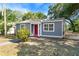 Cozy gray home featuring a red front door, bright windows, and tidy yard at 601 Newton S Ave, St Petersburg, FL 33701