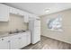 Kitchen with stainless steel sink, white cabinets, and wood-look flooring at 601 Newton S Ave, St Petersburg, FL 33701