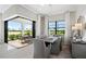 Modern dining room featuring an elegant table, chairs, and a scenic outdoor view at 6017 Silver Grass Ct, Nokomis, FL 34275