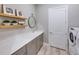 Well-organized laundry room with a white countertop, cabinets, and modern washer at 6017 Silver Grass Ct, Nokomis, FL 34275