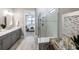 Modern main bathroom featuring double vanity, glass shower, and views into bedroom at 6017 Silver Grass Ct, Nokomis, FL 34275