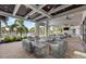 Comfortable covered outdoor seating area with plush sofas, tables, and views of the pool and palms at 6017 Silver Grass Ct, Nokomis, FL 34275
