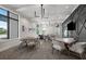 Comfortable seating area with tables, chairs, modern lighting, and wall mounted television at 6017 Silver Grass Ct, Nokomis, FL 34275