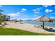 Private beach featuring white sand, tiki umbrellas, and lounge chairs overlooking the serene water at 6021 Bahia Del Mar Cir # 238, St Petersburg, FL 33715