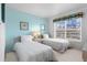 Bright bedroom with two twin beds, large window, and light blue accent wall at 6021 Bahia Del Mar Cir # 238, St Petersburg, FL 33715