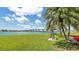 Well-manicured lawn with bench seating under mature palm trees, offering picturesque views of the bridge over the water at 6021 Bahia Del Mar Cir # 238, St Petersburg, FL 33715