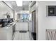 Well-lit kitchen with sleek white cabinets and appliances and views to the water at 6021 Bahia Del Mar Cir # 238, St Petersburg, FL 33715