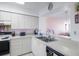 Functional kitchen featuring white cabinetry, countertops and backsplash with stainless steel appliances at 6021 Bahia Del Mar Cir # 238, St Petersburg, FL 33715