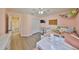 This bedroom has wood floors, a tv, decor, a ceiling fan, and a window at 6107 Heroncrest Ct, Lithia, FL 33547